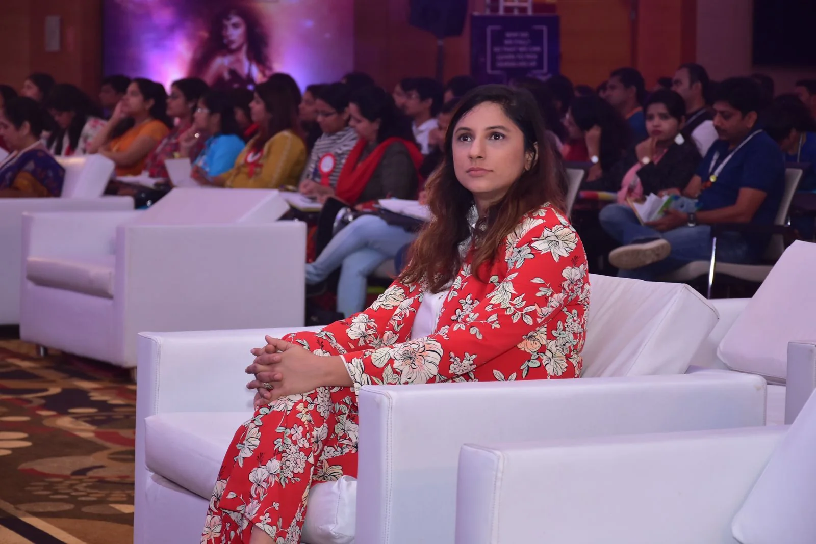 Nidhi Raina seated in the audience at a professional gathering